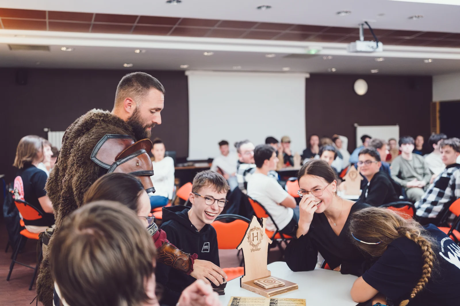 Des participants rient ensemble autour d’une table de Sombreval, accompagnés par Jack